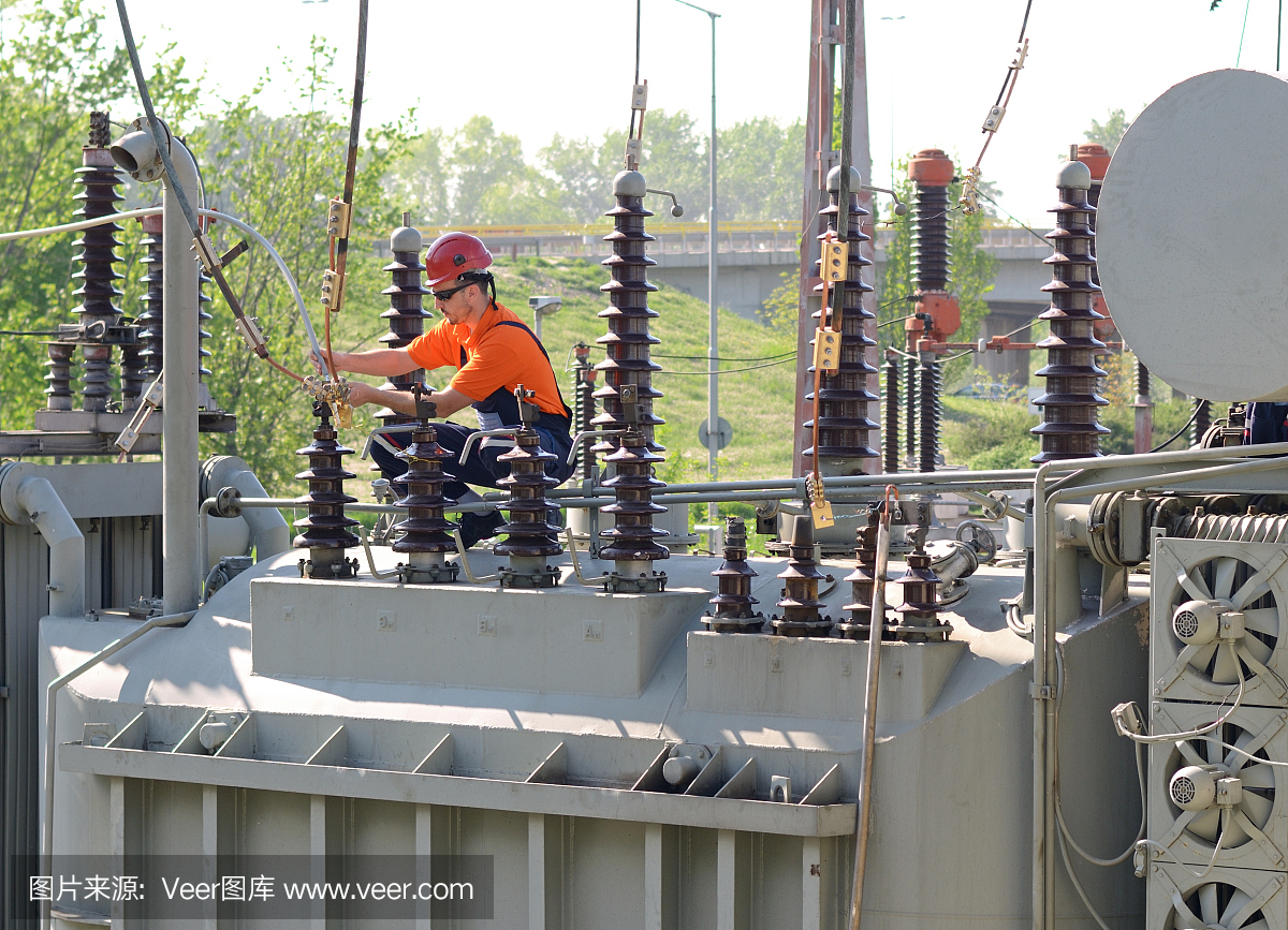 电工在电站高压变压器上工作