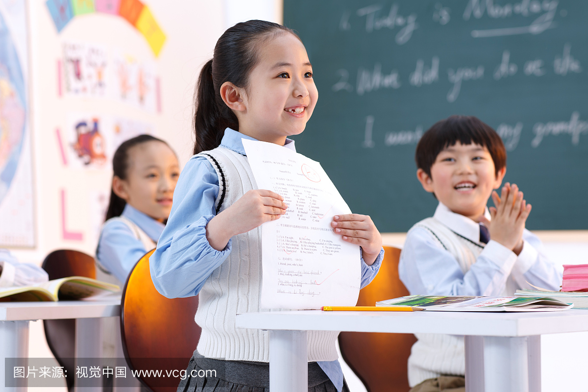 小学生在教室里展示考试卷