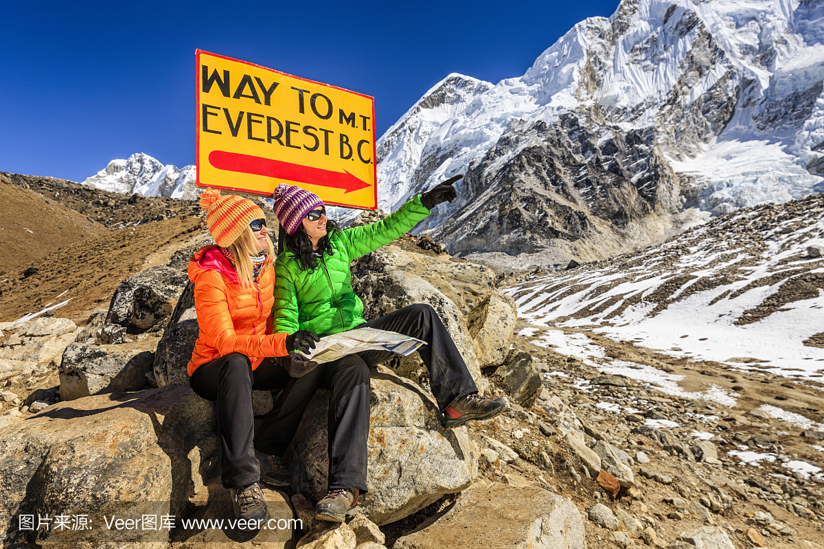 学习地图的年轻女性在路标旁边,尼泊尔喜马拉雅山