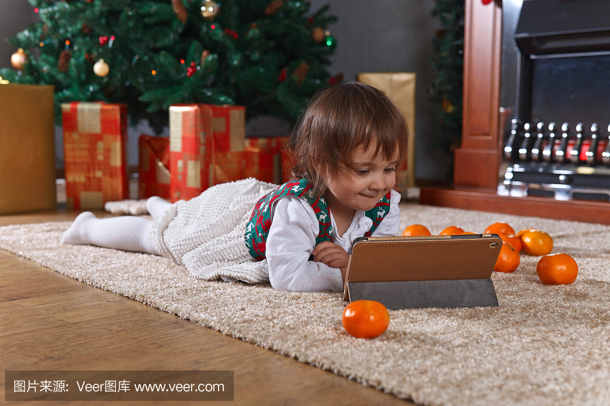 平板电脑的小女孩与房间圣诞装饰品