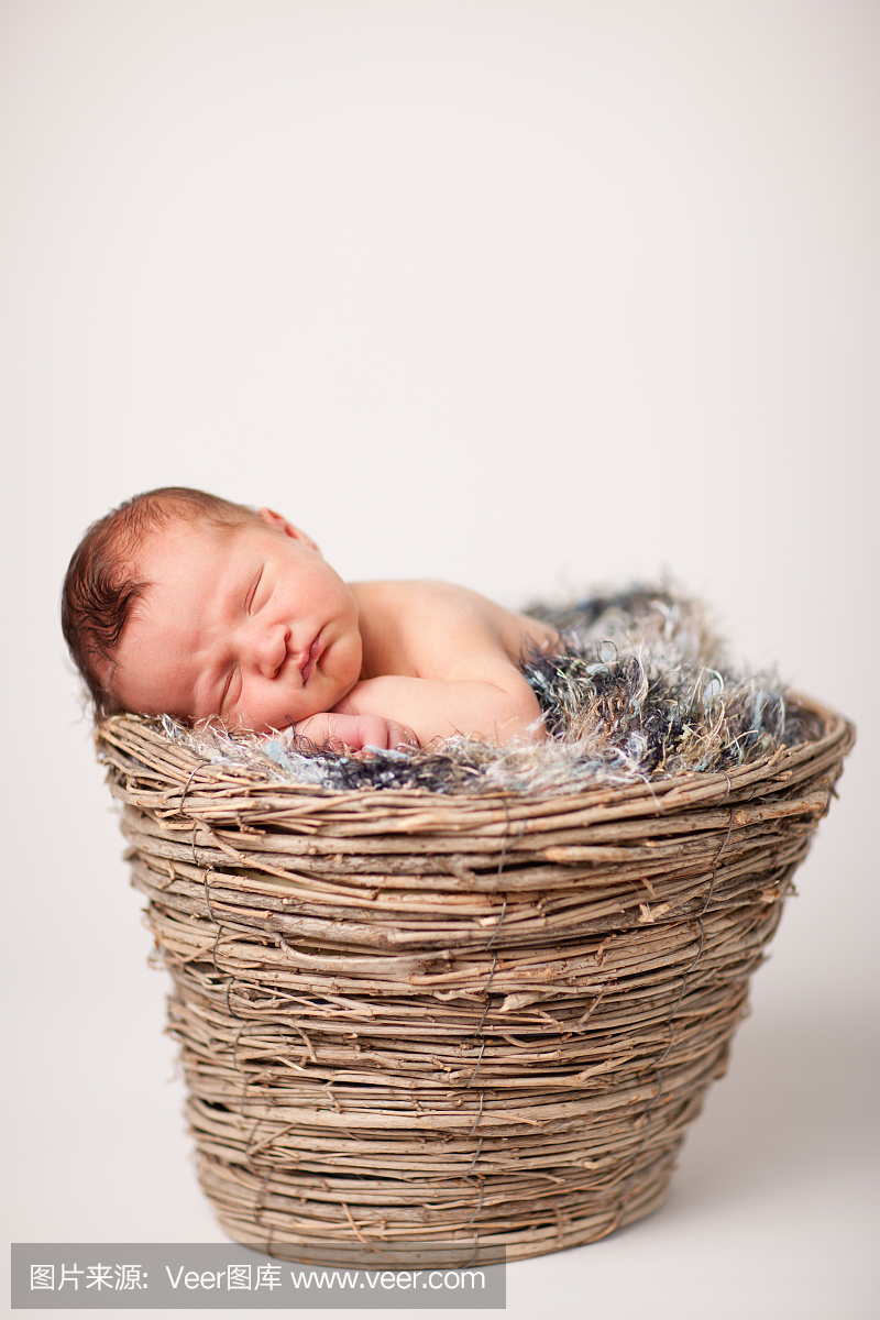 新生婴儿平静地睡在篮子里,模糊的纹理