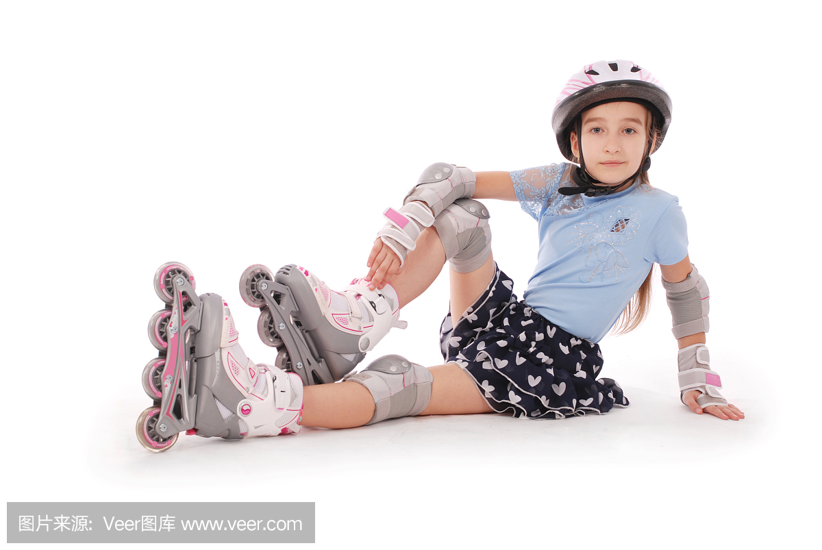 快乐的小女孩,溜冰鞋和防护装备休息。