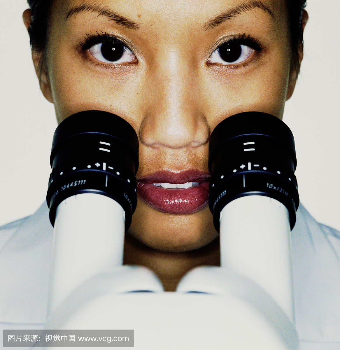 女性实验室技术员与前景显微镜