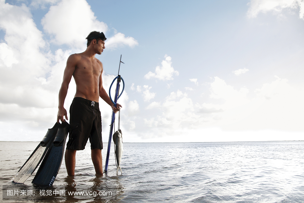 夏威夷,瓦胡岛,拿着他的枪矛,鳍和鱼抓在一条站