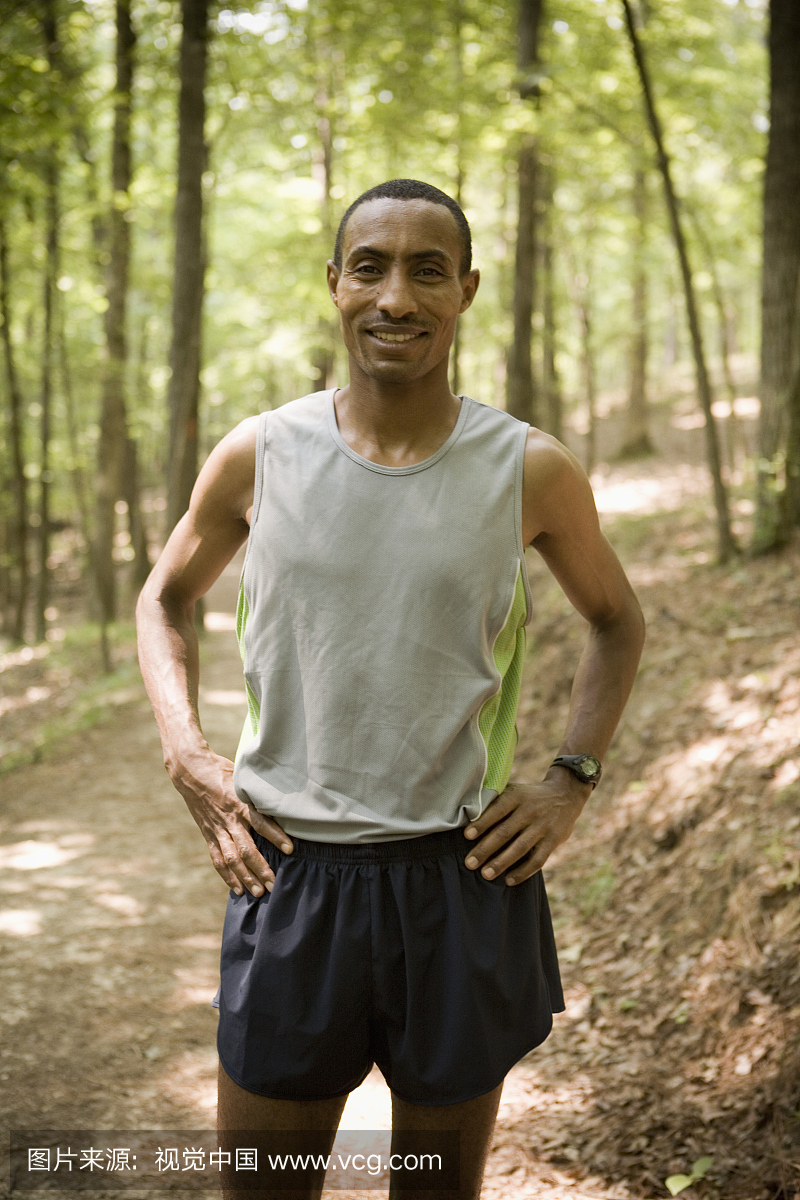男子跑步者在树上用双手臀部,肖像