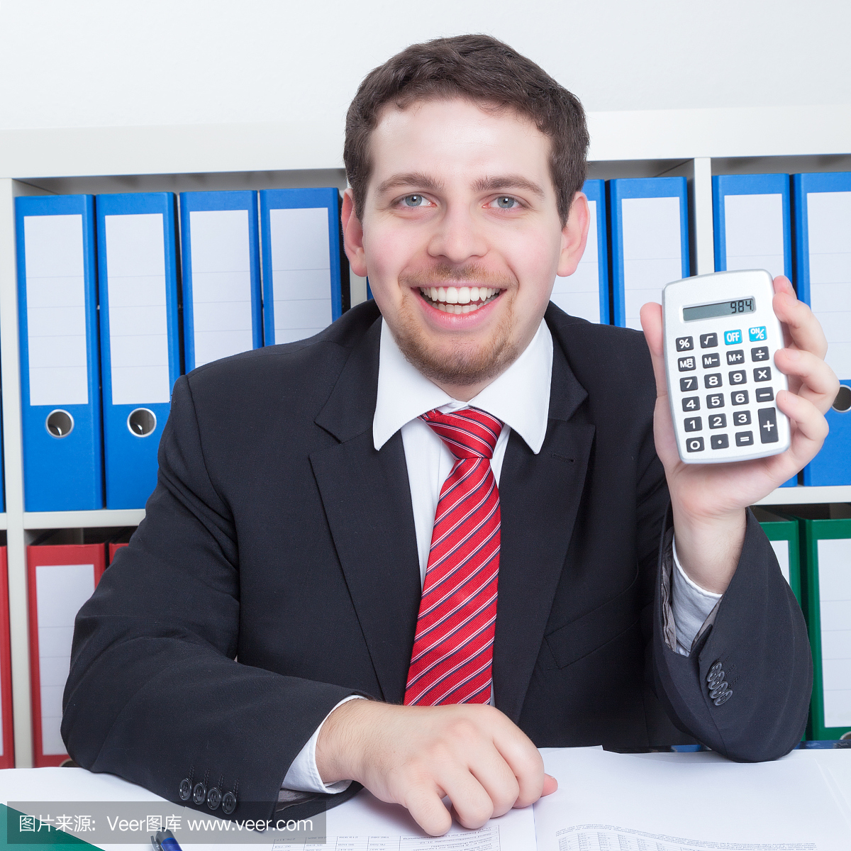 商人在黑色西装在办公室与计算器