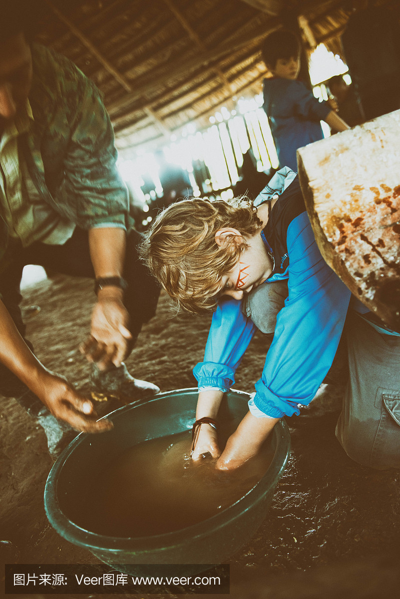 Child washes hands in dirty water in the jungle