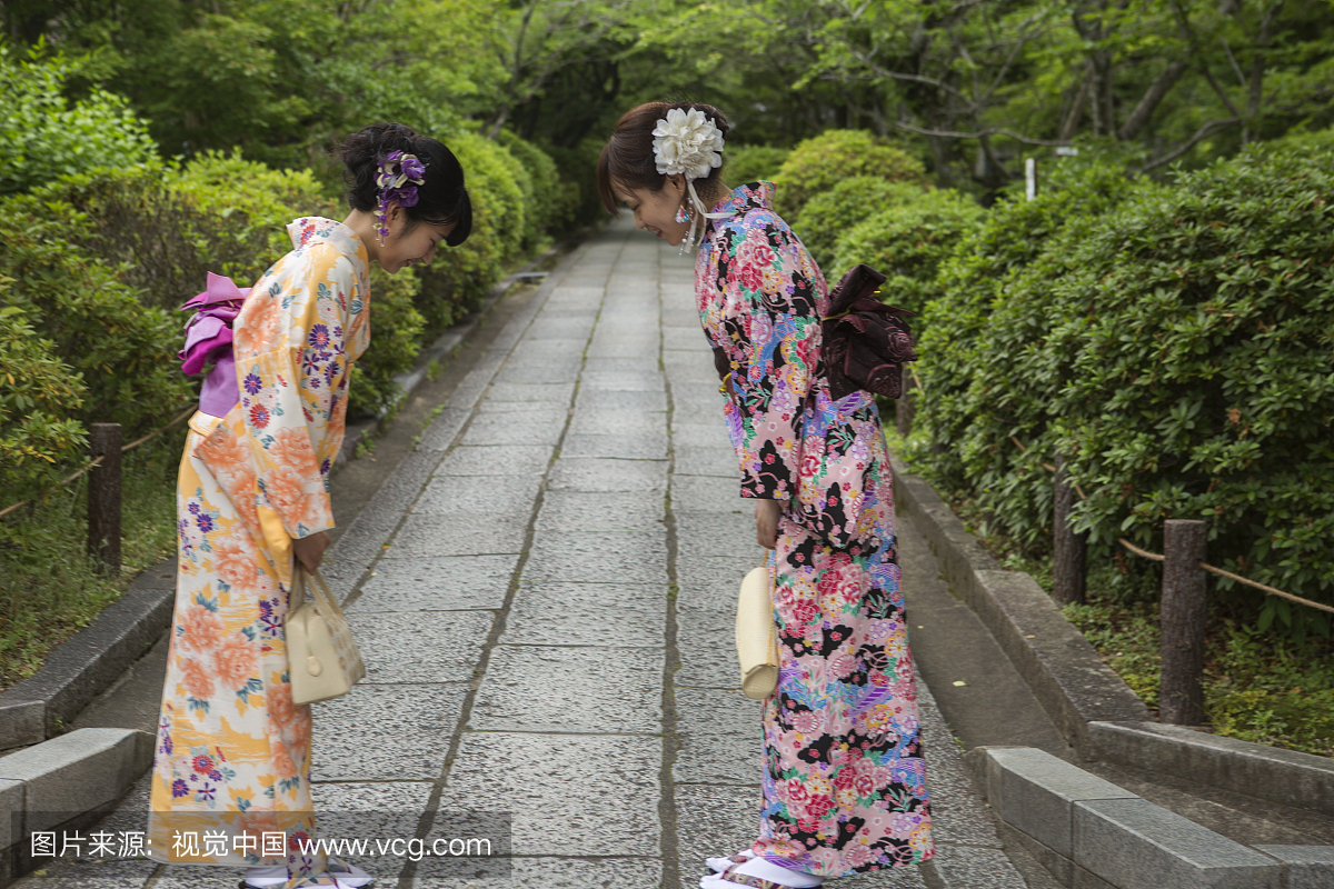 在京都东京穿和服服装敬礼的女孩的女孩