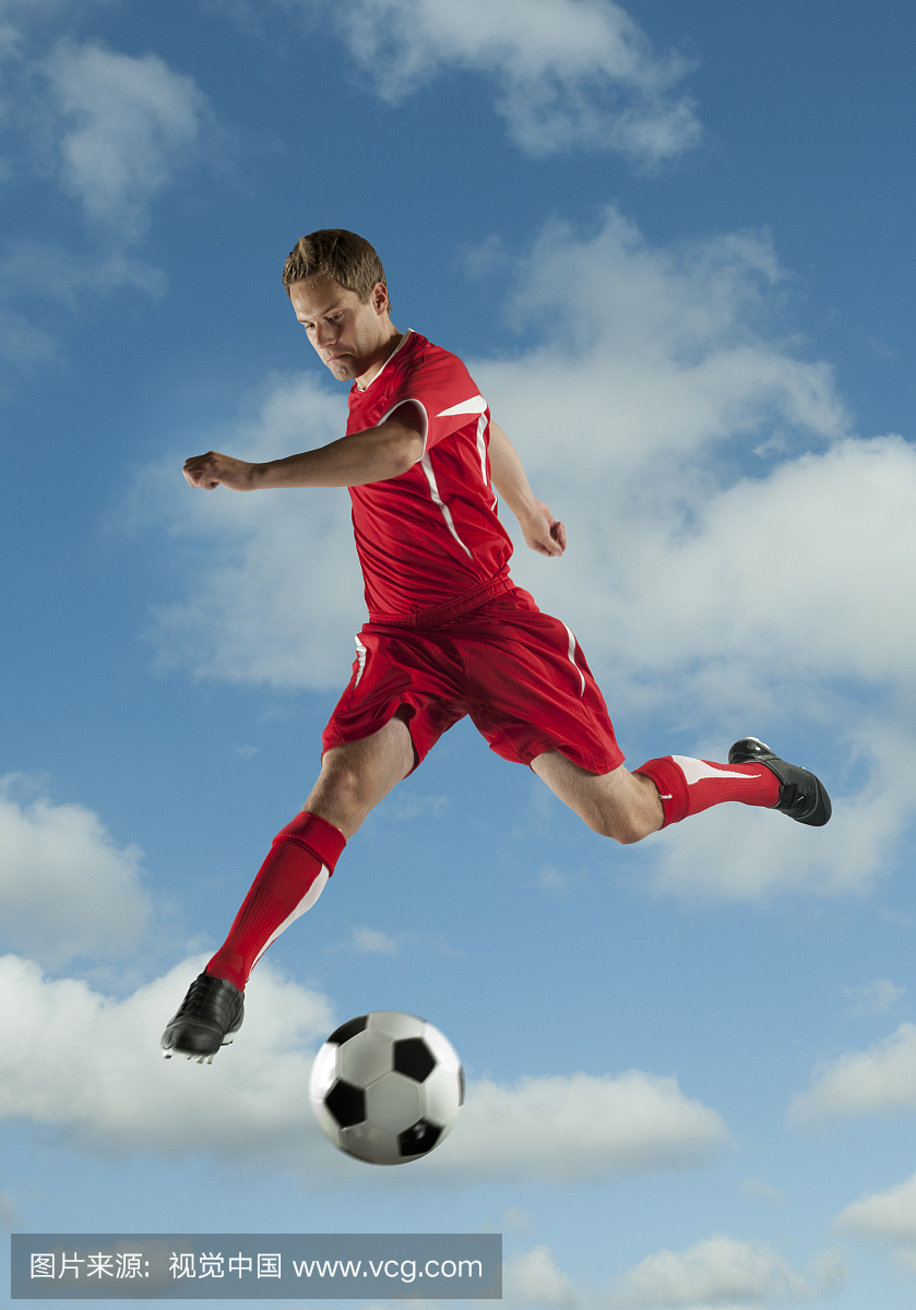 足球运动员在空中踢球跳跃