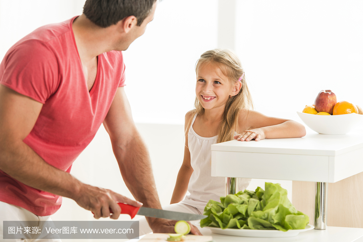 幸福的女儿和她父亲在厨房里沟通。