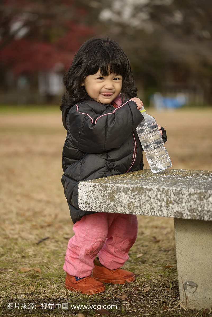小女孩在公园里喝水