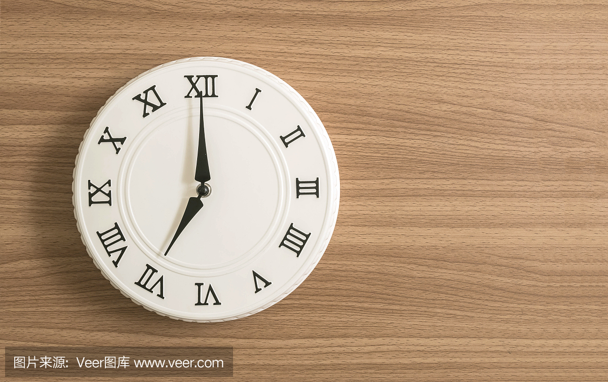 特写白色时钟为装饰在木桌上的7点纹理背景与副本空间