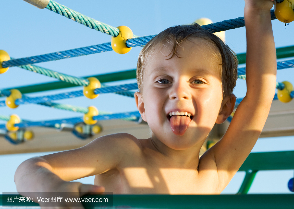 小男孩在丛林健身房玩耍。