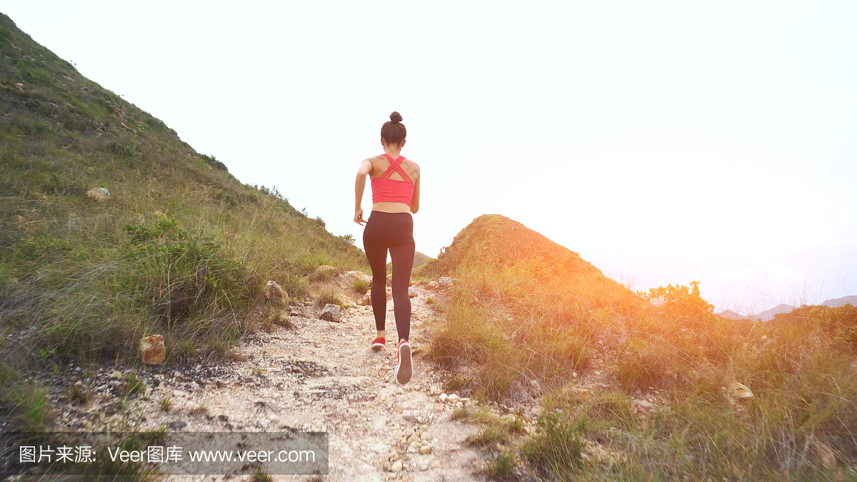 在山路上跑步的女人。体育女孩在山外锻炼身体