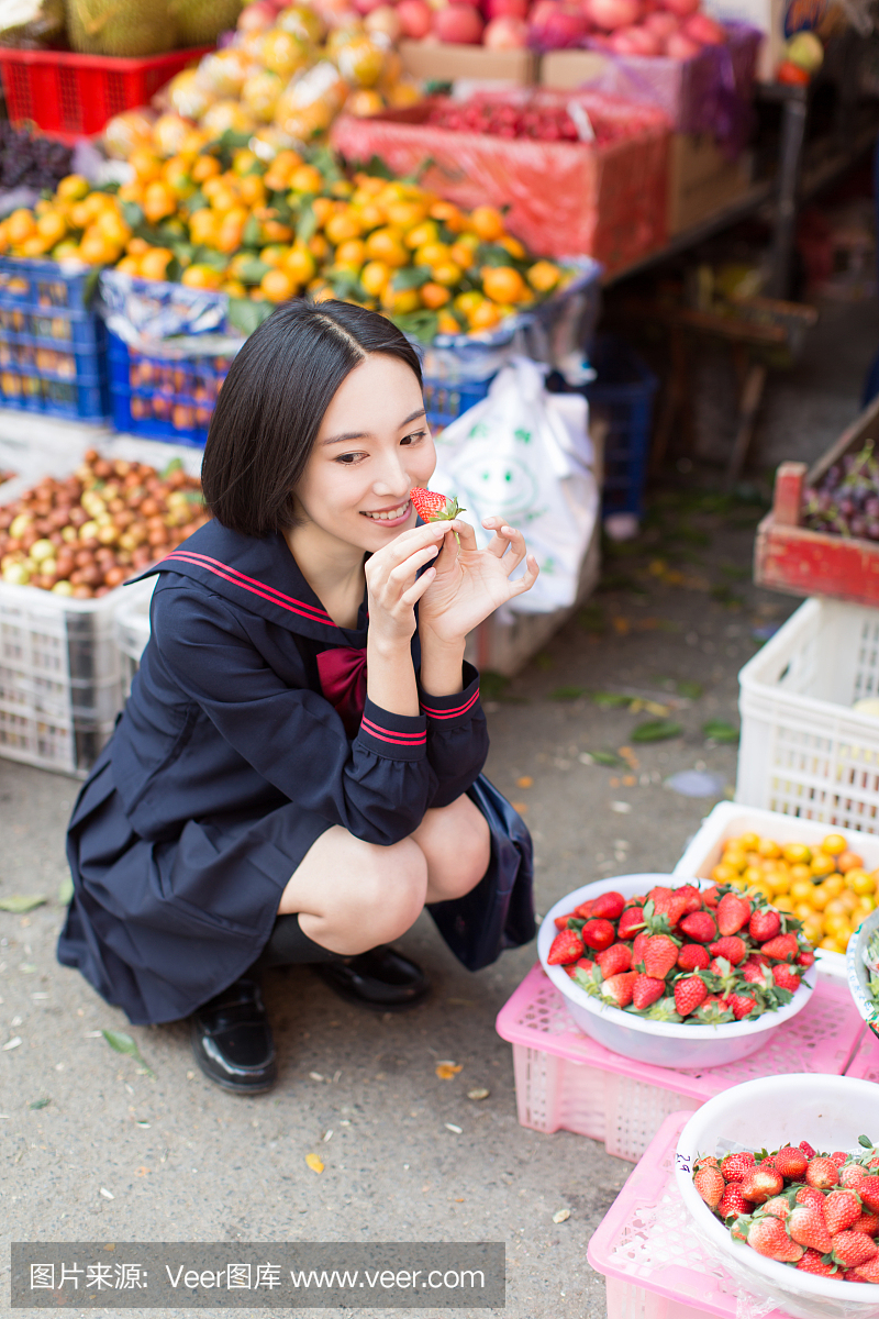 美丽的中国女学生在市场上买水果和蔬菜