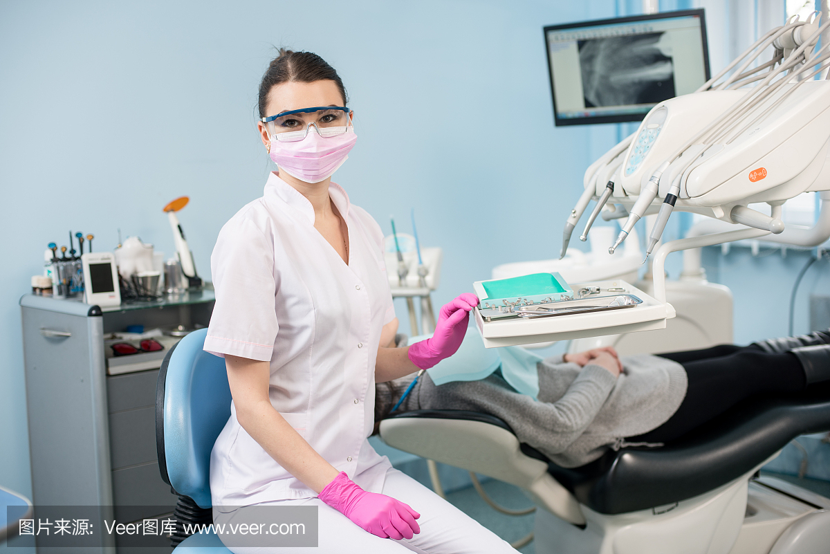 有吸引力的女牙医与患者在牙科诊所的肖像。医
