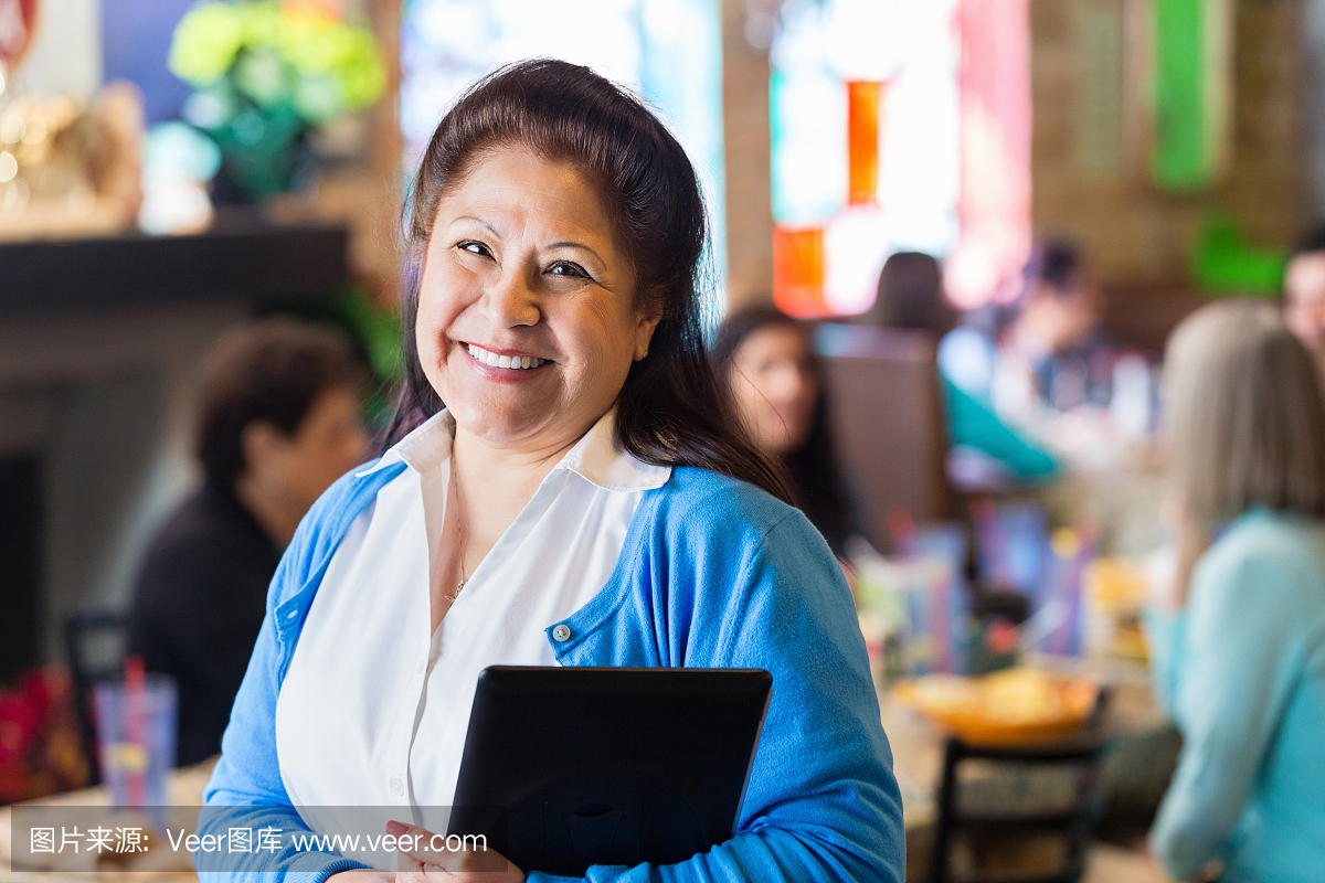 西班牙裔祖母与数字平板电脑在家庭Tex-Mex餐