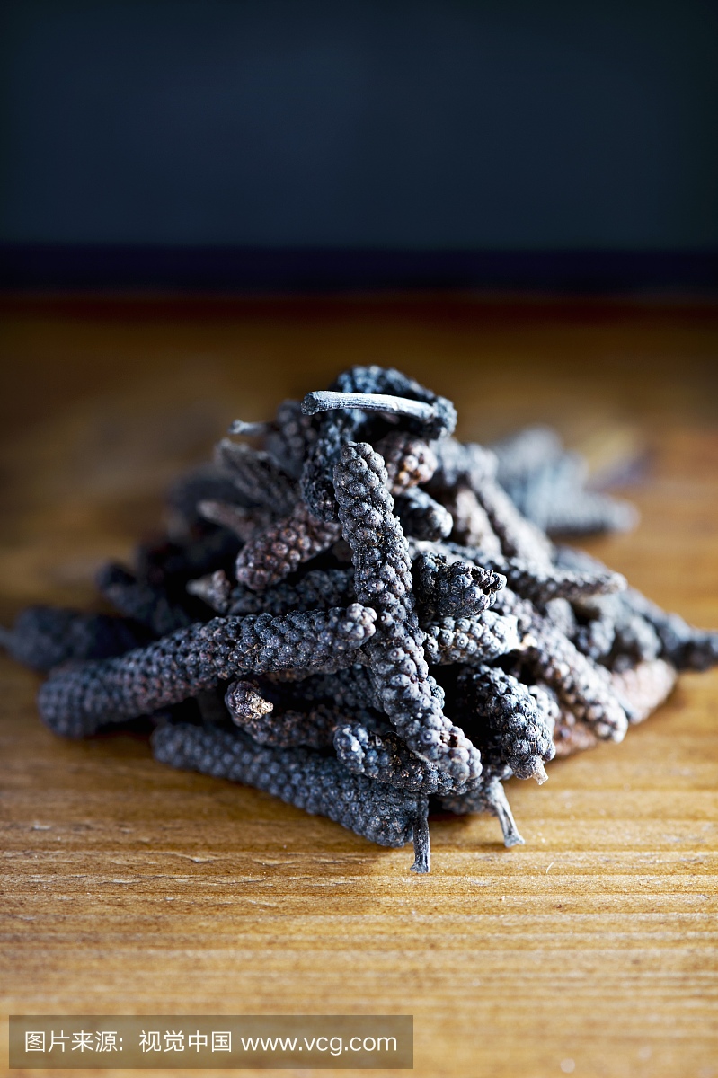 A close-up on long Java pepper on a rustic woo