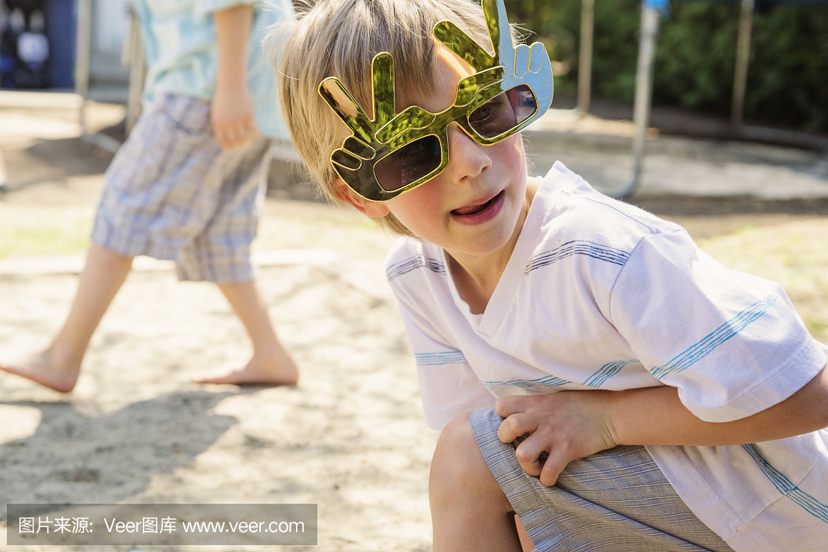 有大玩具的小男孩有趣的眼镜在后院玩。