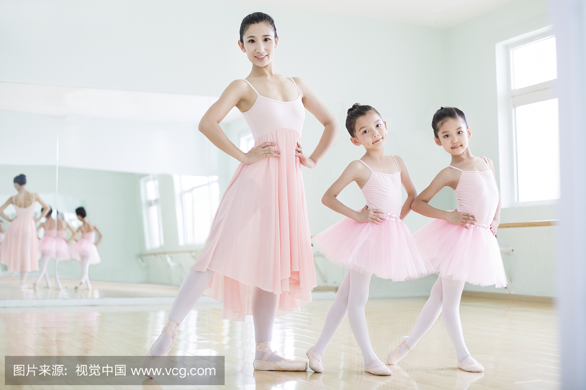 年轻舞蹈老师教小女孩们跳芭蕾