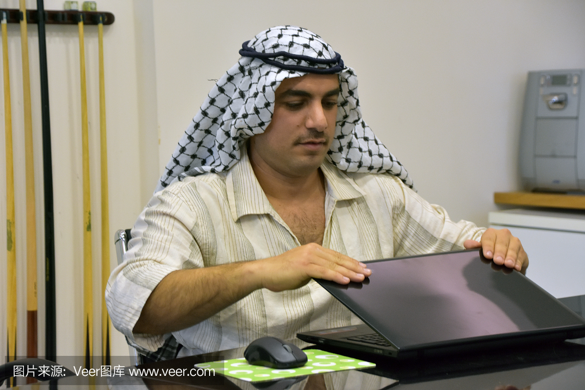 年轻阿拉伯男子在会议室使用笔记本电脑
