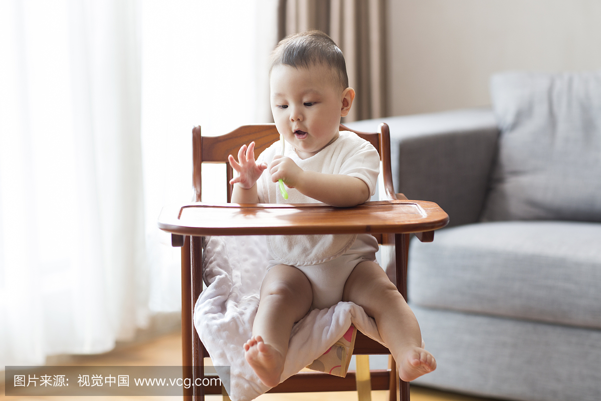 可爱的宝宝坐在儿童餐椅里