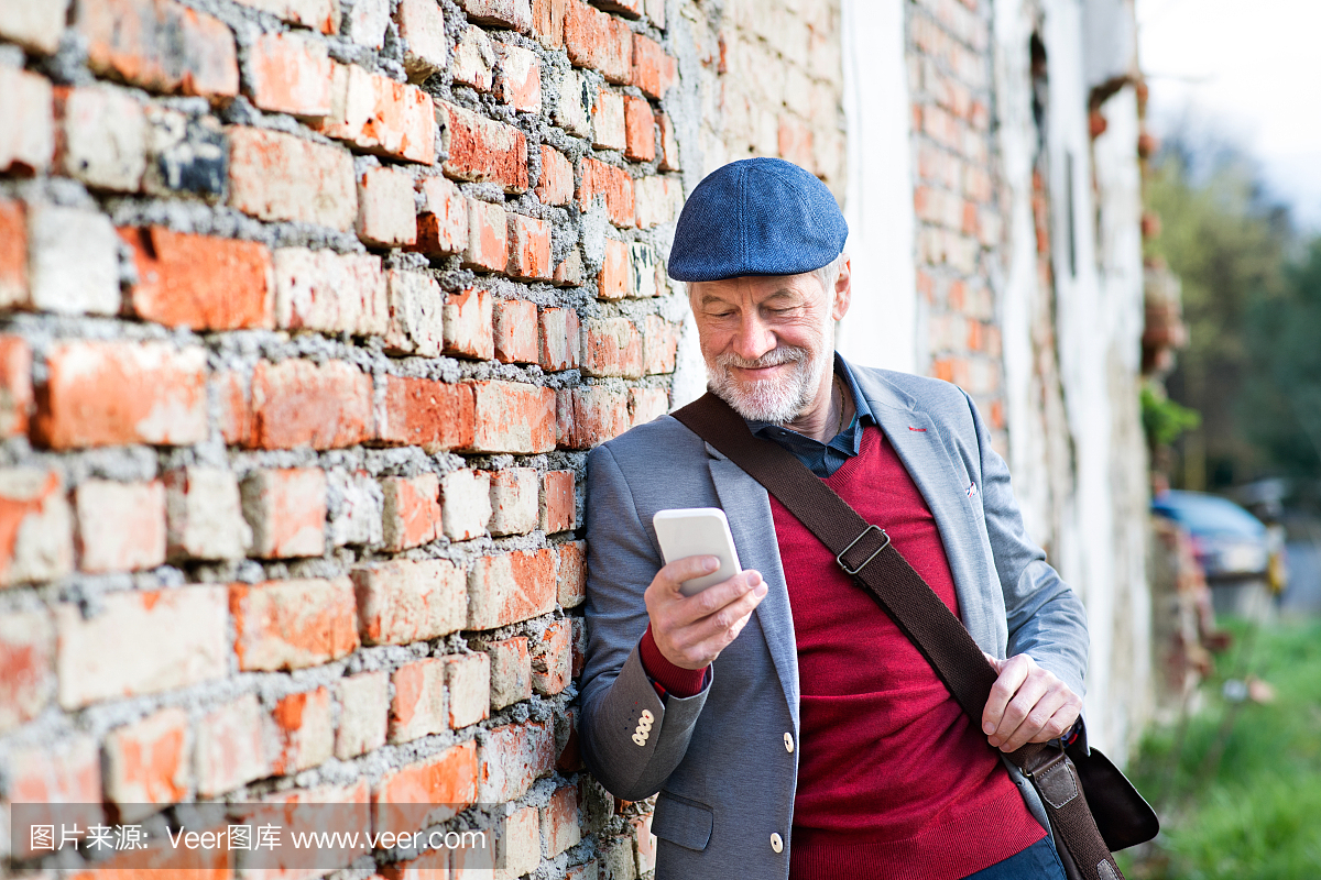 老人用智能手机反墙砖,发短信。