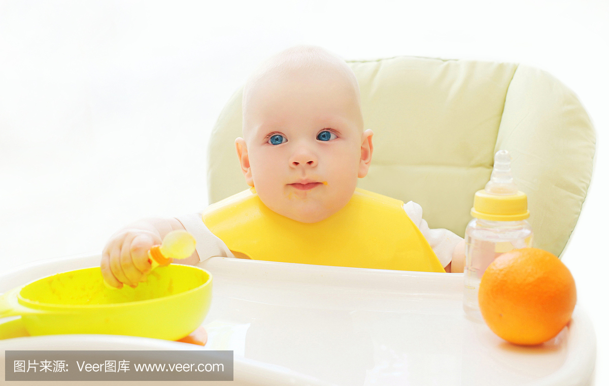 宝宝坐在桌子的家里吃勺子