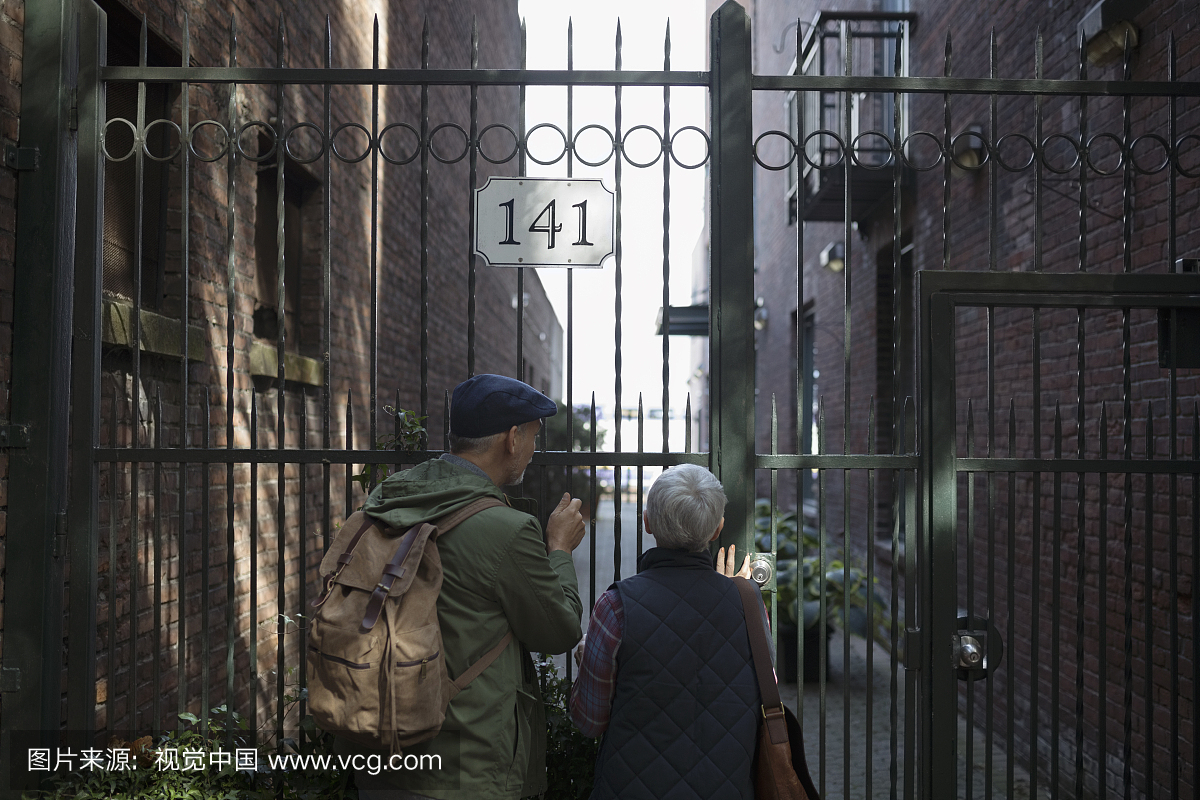 年长的夫妇看门外的城市公寓