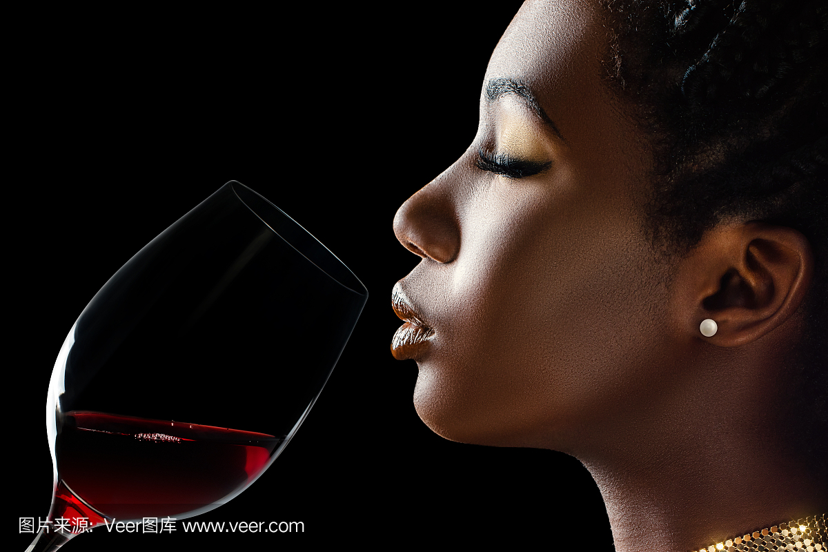 非洲女人闻起红酒的香气。