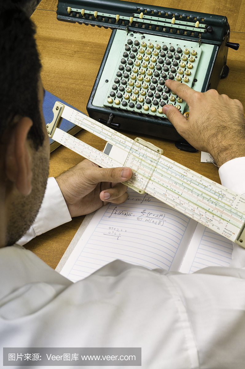 男学生使用老式幻灯片规则计算器