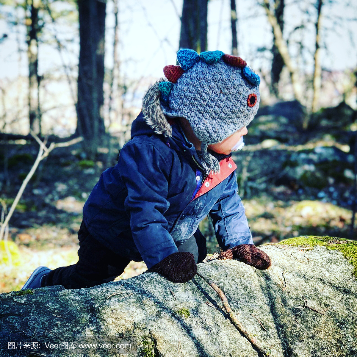 小男孩爬上岩石
