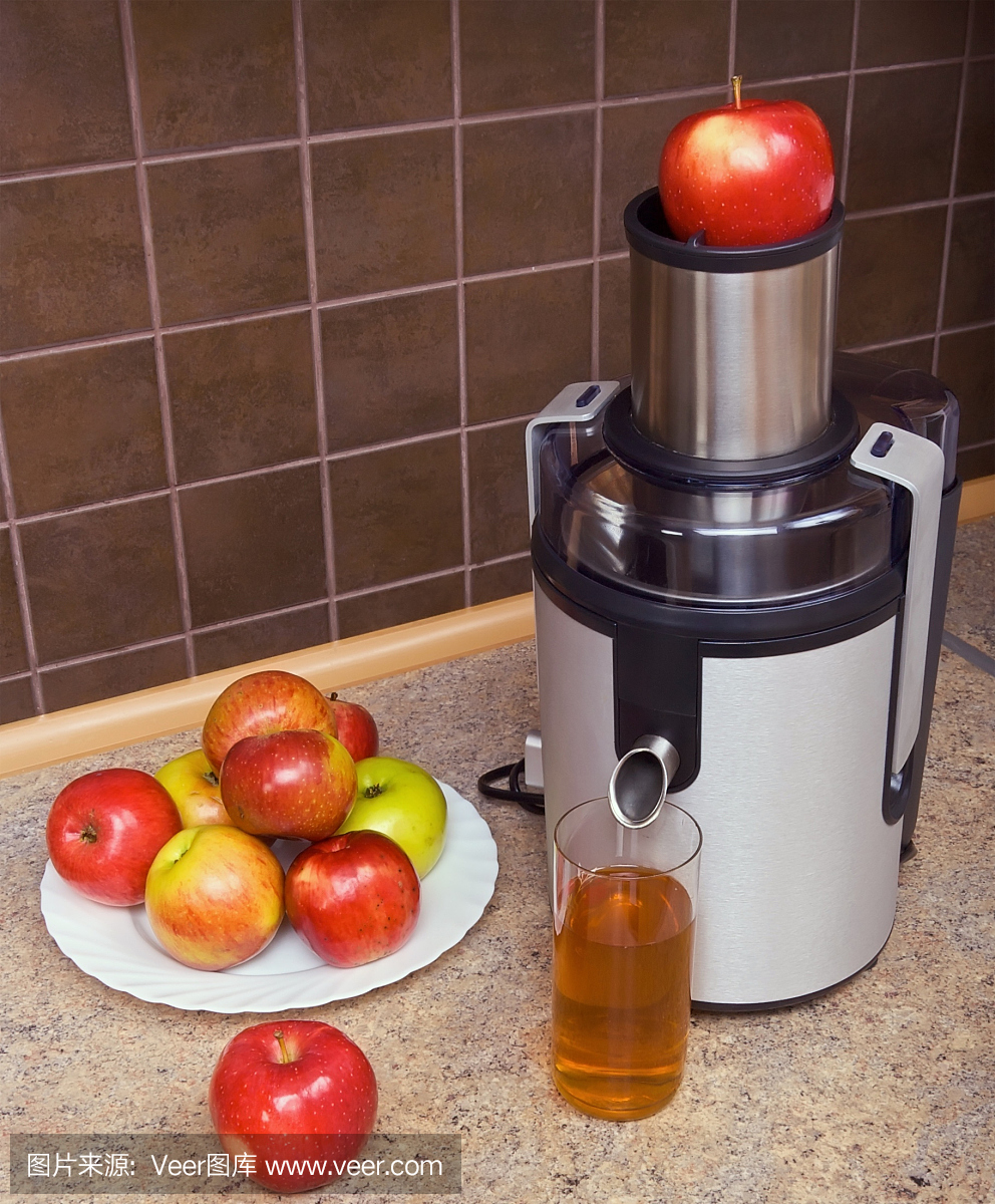 榨汁机,苹果,一杯果汁在厨房的桌子上