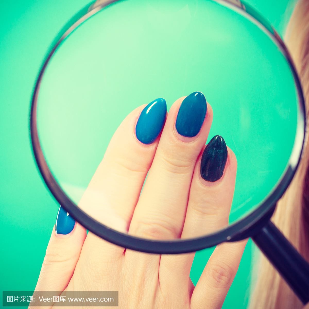 看着指甲的女人通过放大镜