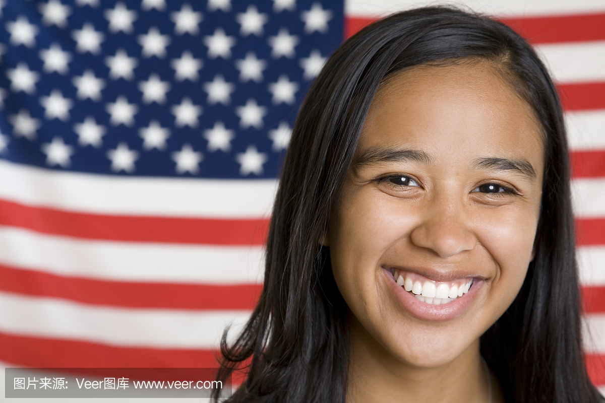 可爱的年轻西班牙裔美国女孩在美国国旗前面