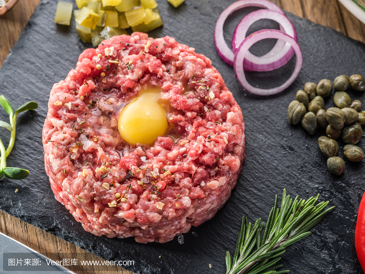 牛排鞑靼配生鹌鹑蛋黄和其他鞑靼成分。顶视图