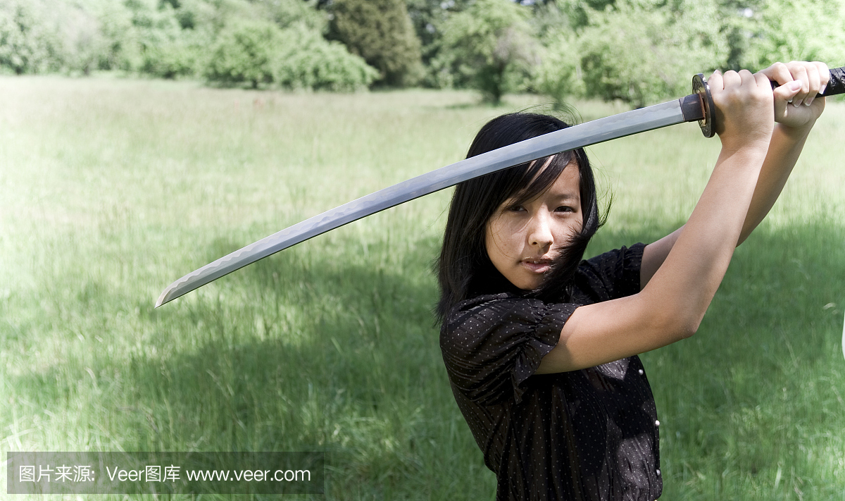 年轻的忍者女孩与绘制的Katana剑的领域