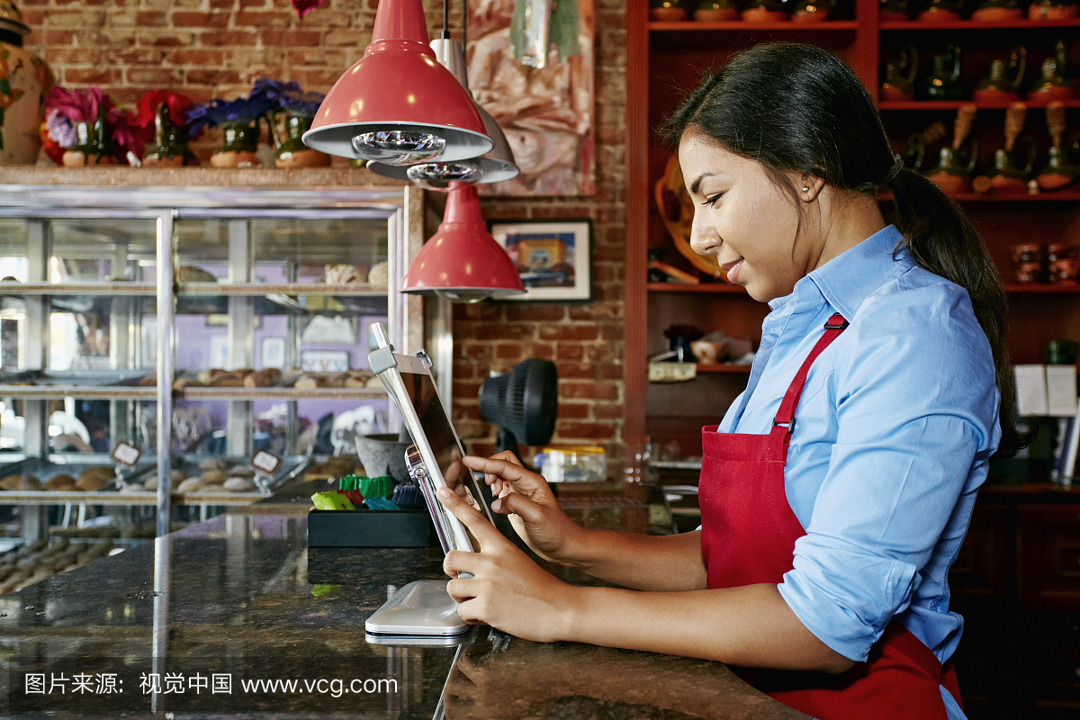 西班牙收银员在面包店使用数字平板电脑