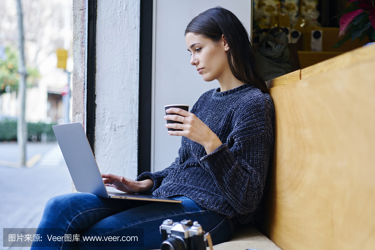 考黑发摄影师穿着时髦的衣服,搜索网页中的信