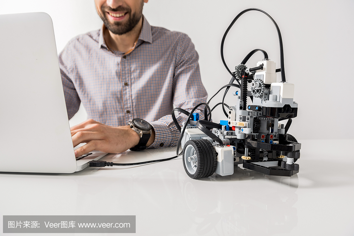 快乐的未剃毛工程师在笔记本电脑上打字