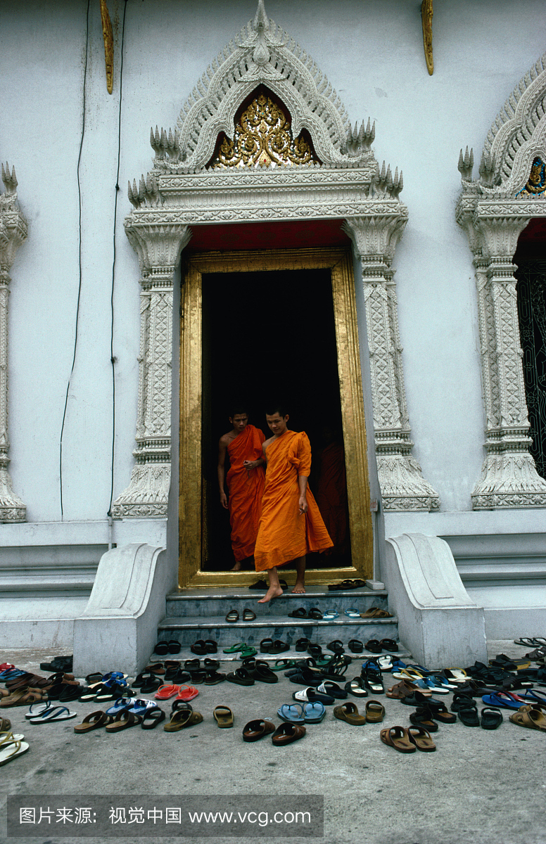 名僧侣,在他们前面的地面上有游客鞋和凉鞋。
