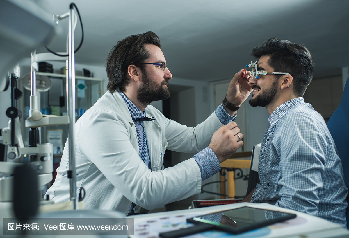 眼科医生用一个年轻人进行视力检查,试用期。