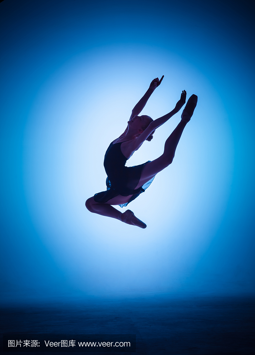 跳跃在蓝色的年轻芭蕾舞蹈家的剪影