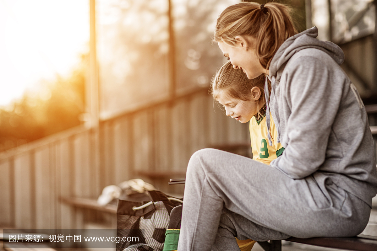 年轻的金发女子足球教练和她的女孩足球队