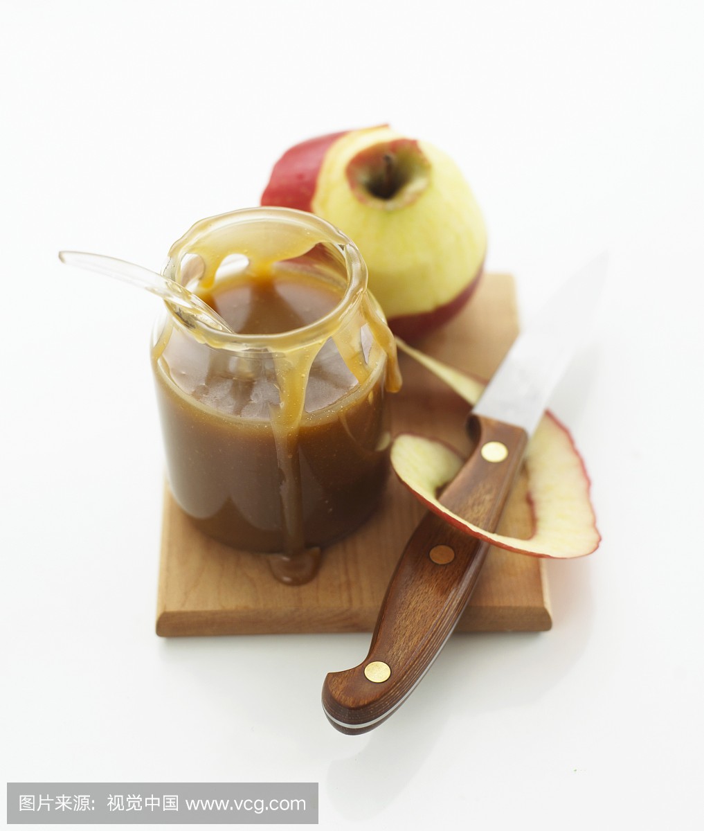 Apple caramel sauce in jar and peeled apple o