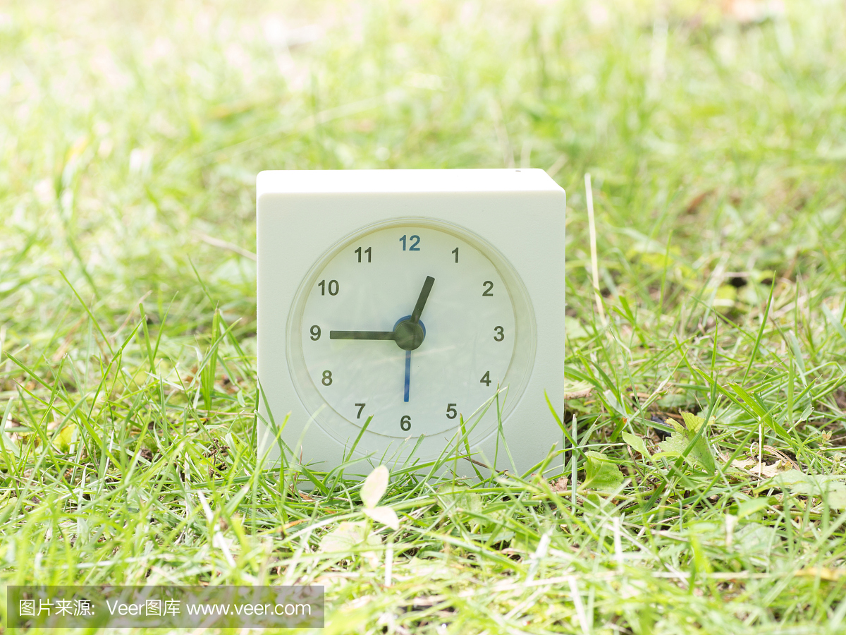 白色简单的时钟在草坪上,12:45十二点五十五分