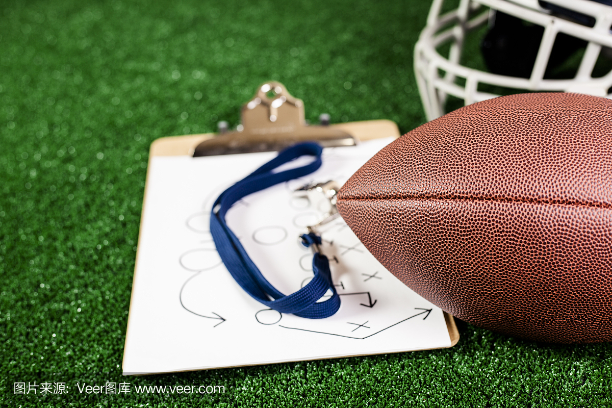 足球教练的口哨,足球,球员的头盔在绿草皮上。