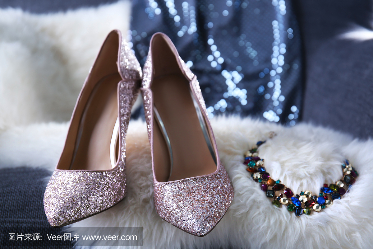 美丽的高跟鞋和珠宝在毛茸茸的地毯上