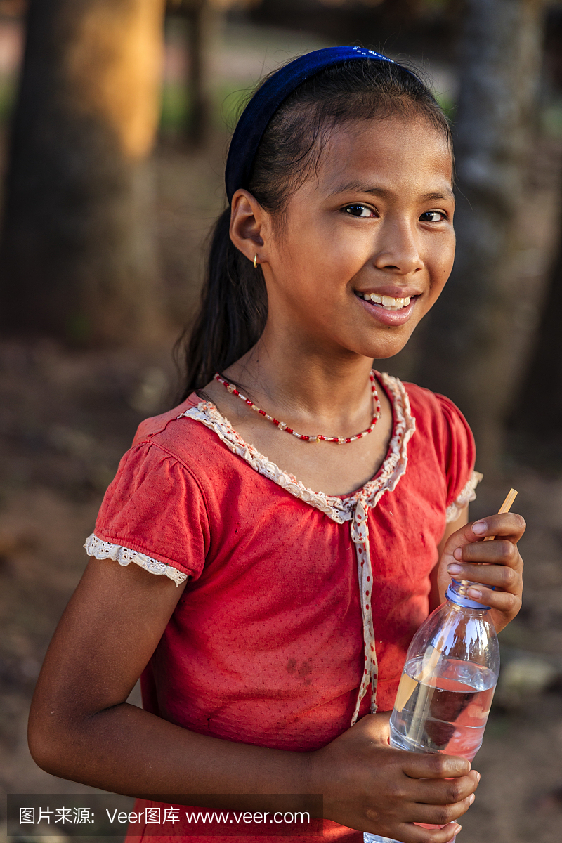 喝新鲜的水,柬埔寨的愉快的柬埔寨女孩画象
