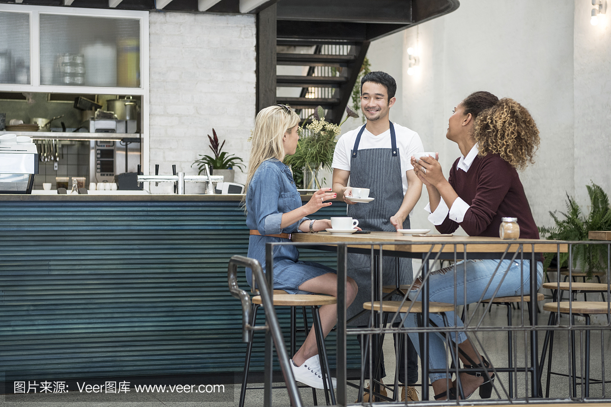 男服务员在咖啡厅服务两名年轻女子